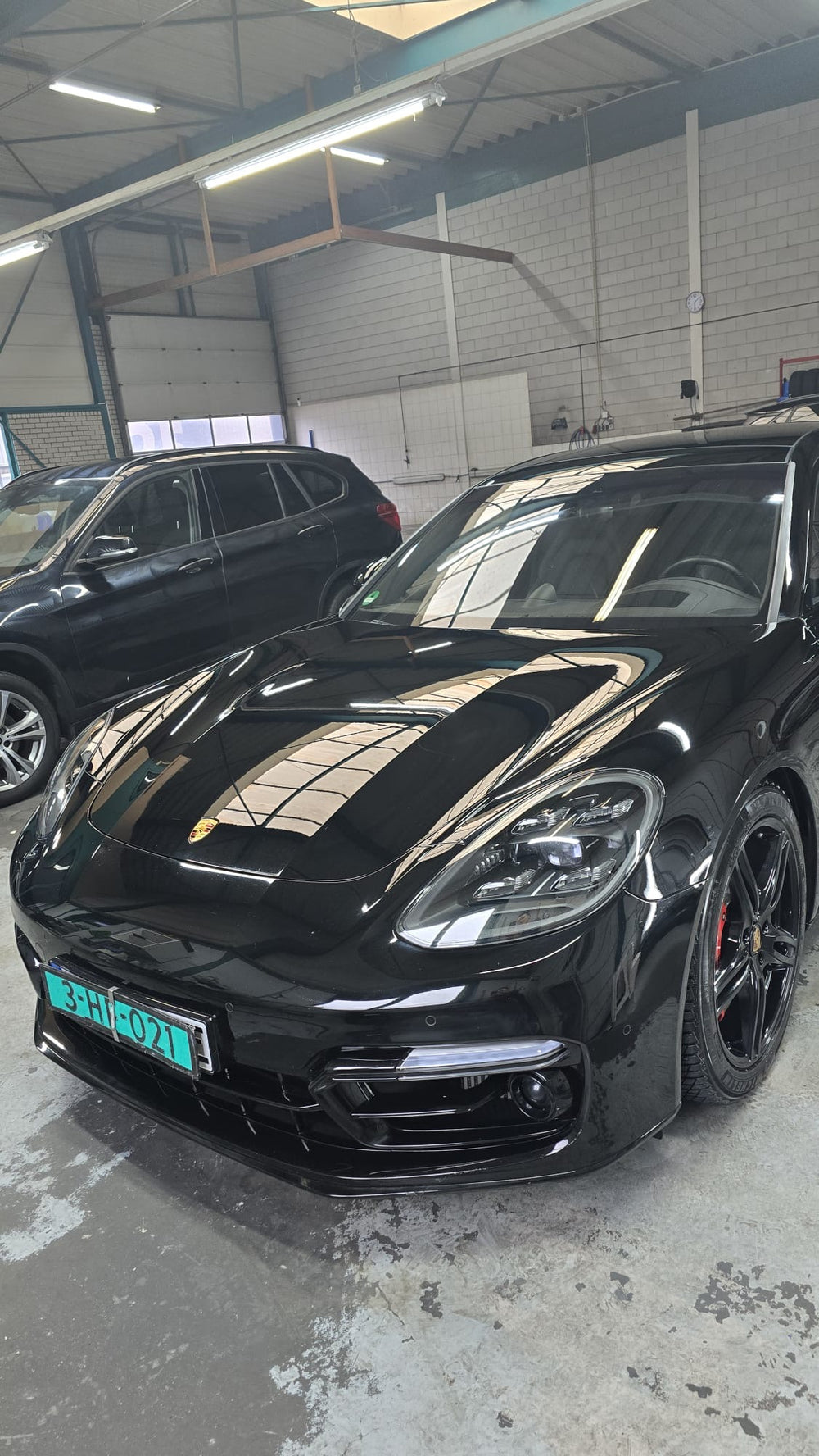 Zwarte Porsche Panamera met diepe glans in de werkplaats van Blink&Go